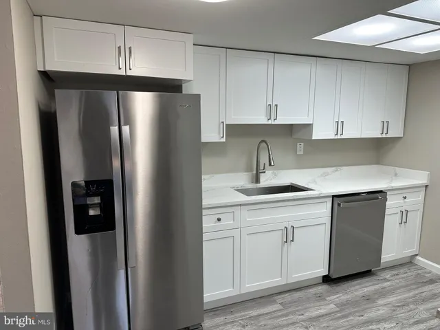 a kitchen with a refrigerator sink and cabinets