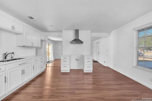 a kitchen with granite countertop a stove top oven sink and cabinets