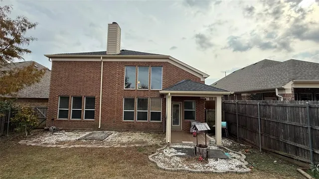 a view of a house with a large window and wooden fence