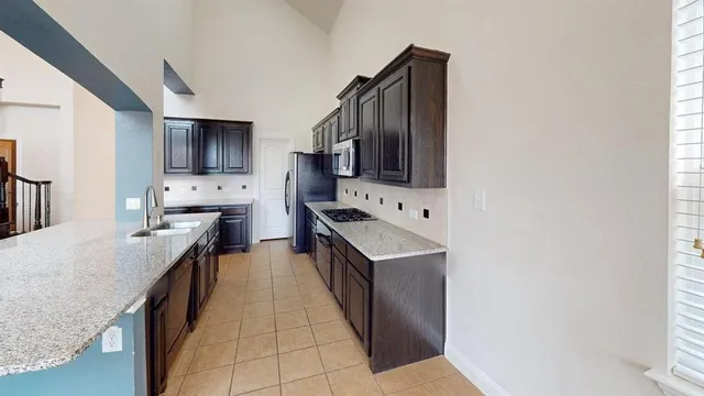 a kitchen with stainless steel appliances a sink stove top oven and refrigerator