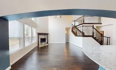 a view of a hallway with wooden floor and staircase