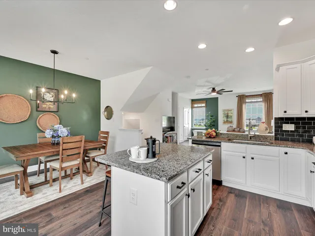 a kitchen with granite countertop a sink stove and cabinets