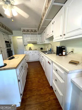 a kitchen with a sink a counter top space stainless steel appliances and cabinets
