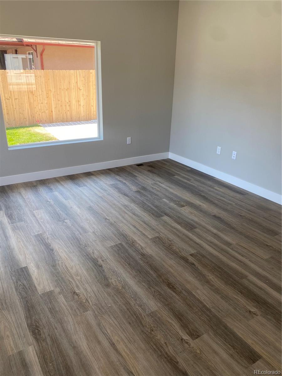 81 North Meade Denver, CO 80219 - Photo 4 of 19 a view of an empty room with wooden floor and a window