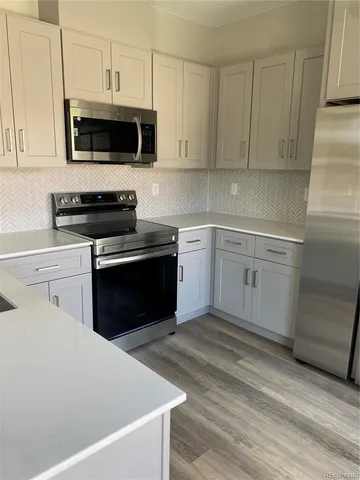 a kitchen with stainless steel appliances a stove a sink and a microwave