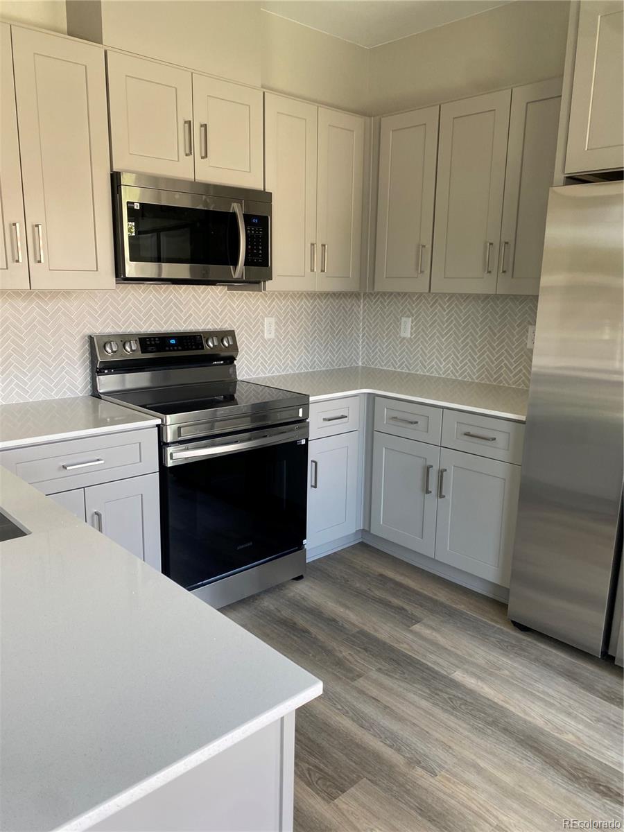 81 North Meade Denver, CO 80219 - Photo 7 of 19 a kitchen with stainless steel appliances a stove a sink and a microwave