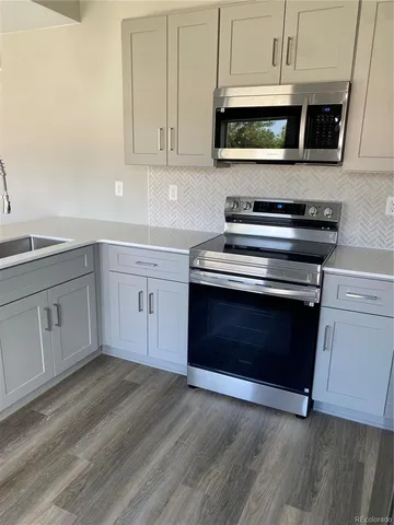 a kitchen with stainless steel appliances granite countertop a stove microwave and cabinets