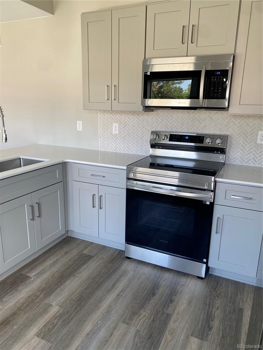 81 North Meade Denver, CO 80219 - Photo 9 of 19 a kitchen with stainless steel appliances granite countertop a stove microwave and cabinets