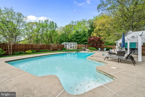 swimming pool view with a seating space and a garden view