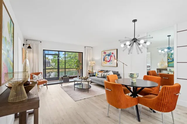 a living room with furniture kitchen view and a large window