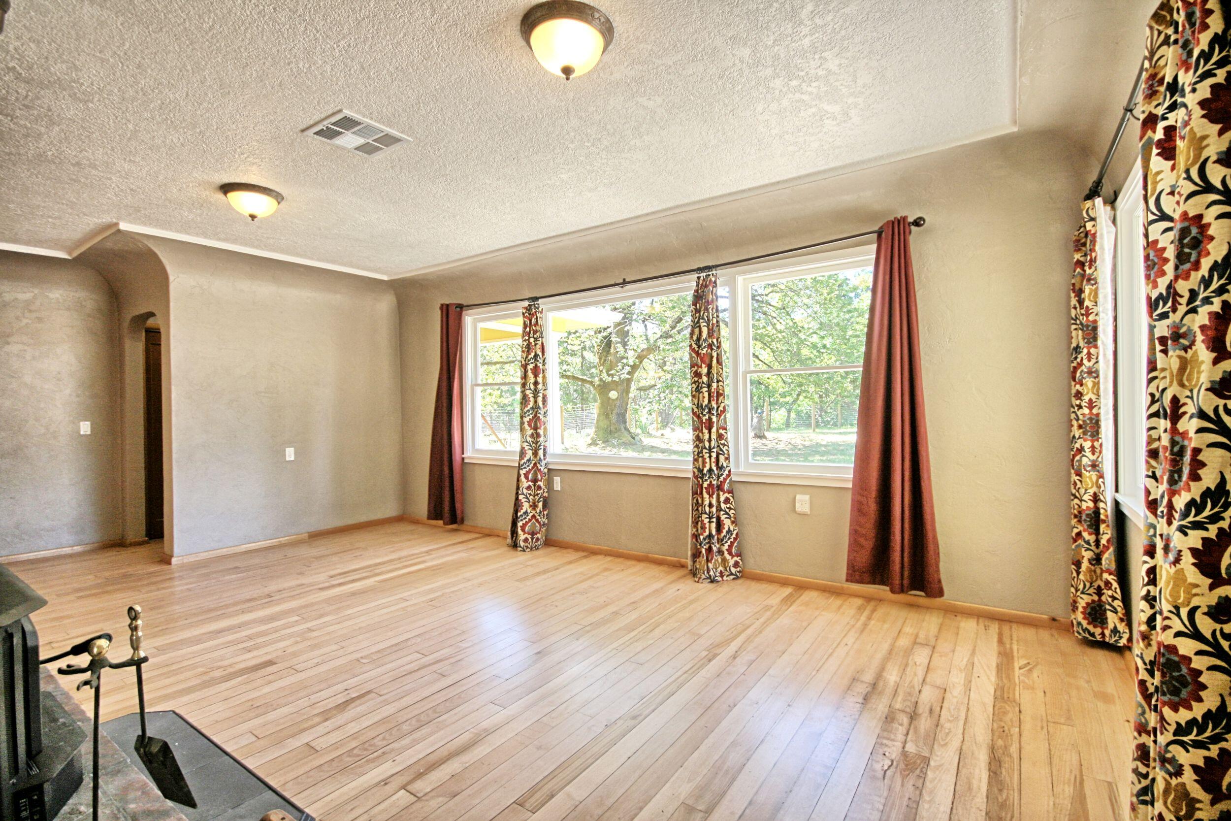 199 Powell Creek Road Williams, OR 97544 - Photo 15 of 57 a view of an empty room with a window and wooden floor