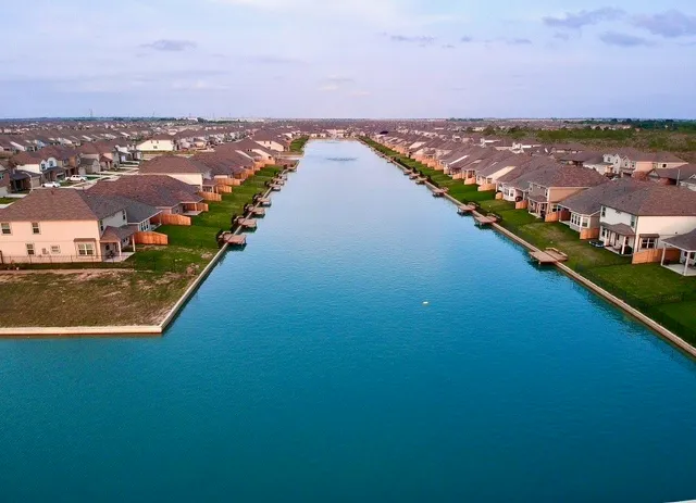 an aerial view of ocean and residential houses with outdoor space