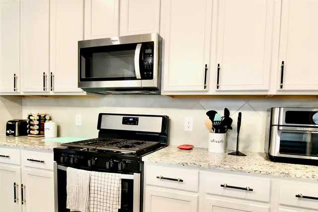 a kitchen with stainless steel appliances granite countertop a sink stove and microwave