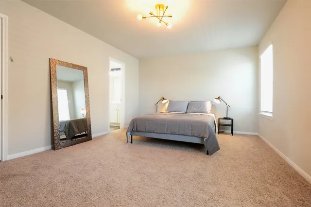 a bedroom with a bed a couch and dresser