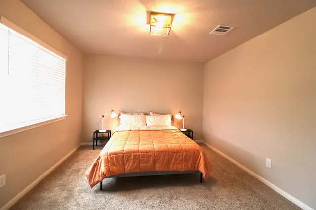 a bedroom with a bed and a window