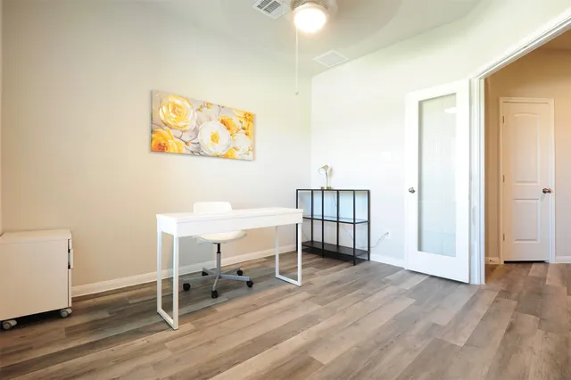 a view of a workspace with furniture and wooden floor