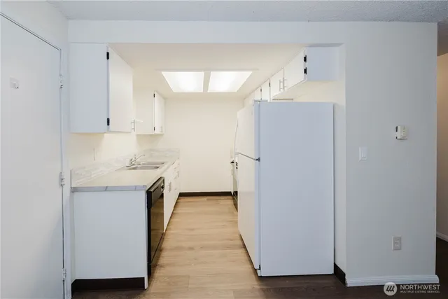 a kitchen with a sink a refrigerator and cabinets