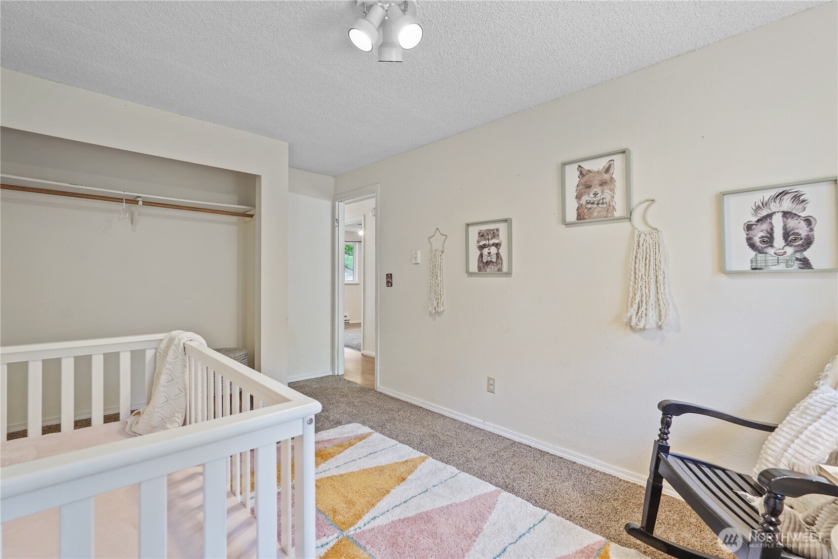 70 East Huckleberry Drive Grapeview, WA 98546 - Photo 19 of 25 a view of a bedroom with baby crib and a wooden floor