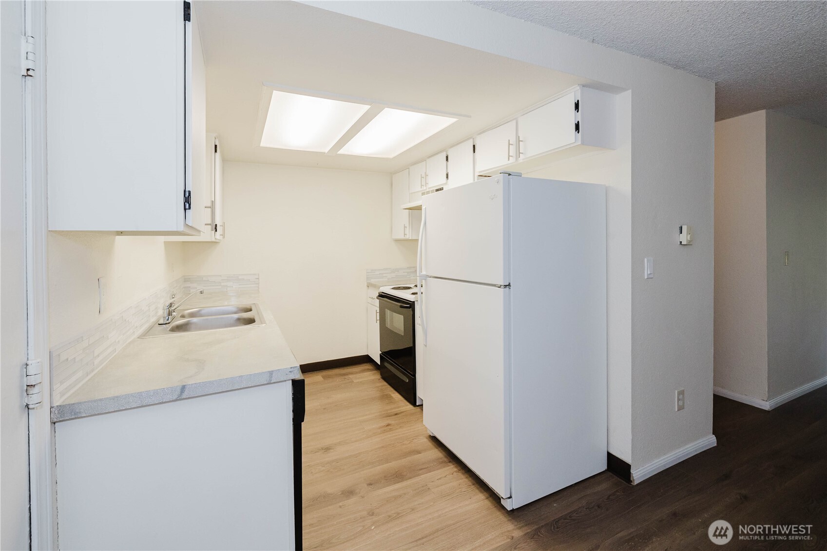 70 East Huckleberry Drive Grapeview, WA 98546 - Photo 8 of 25 a kitchen with a refrigerator a sink and wooden floor