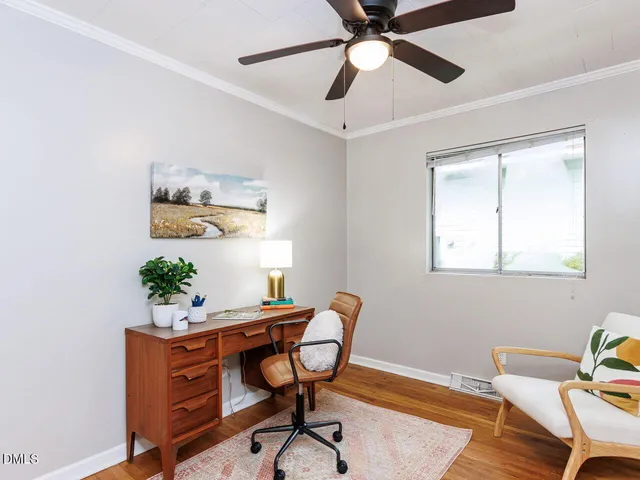 a view of a workspace with furniture and a window
