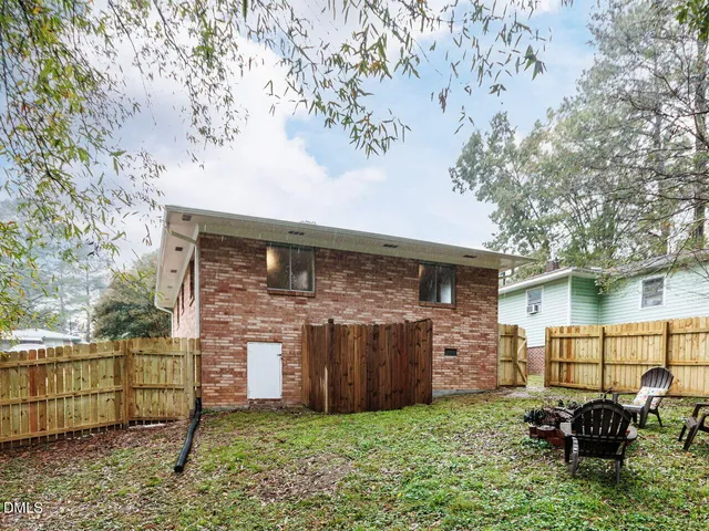a brick house with a small yard and a large tree