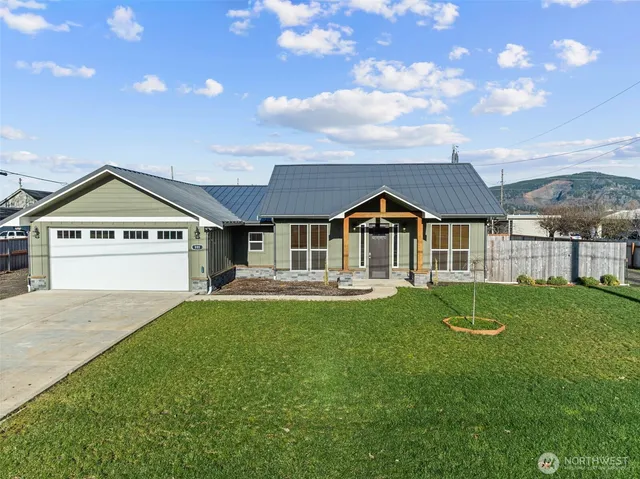 a view of a house with a big yard and large trees