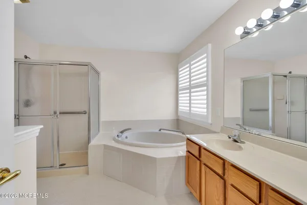 a bathroom with a tub a sink and mirror