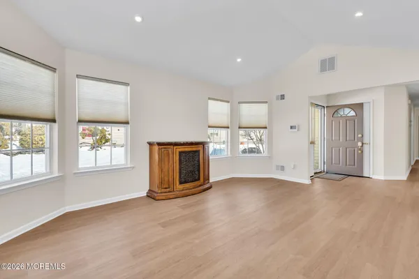 an empty room with windows and fireplace