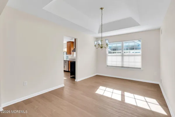 a view of empty room with wooden floor and window