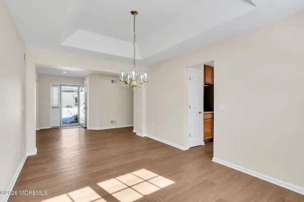 a view of empty room with wooden floor and ceiling fan