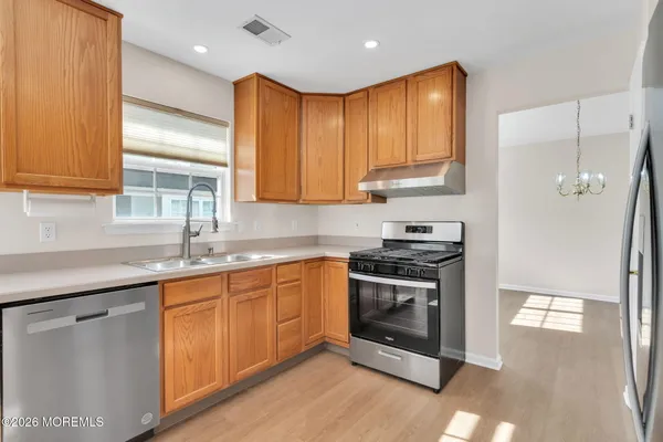 a kitchen with stainless steel appliances granite countertop a stove a sink and a microwave