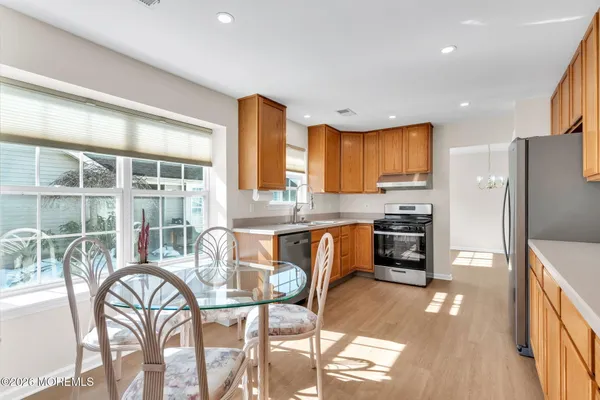 a kitchen with stainless steel appliances granite countertop a stove a refrigerator a oven a sink with island and chairs in it