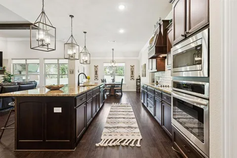 a kitchen with kitchen island granite countertop lots of counter top space and stainless steel appliances