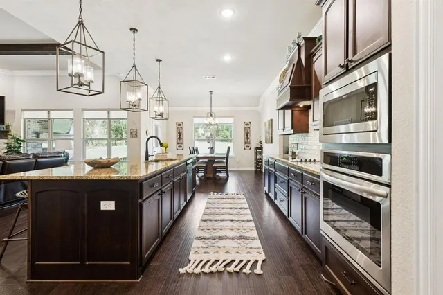 a kitchen with kitchen island granite countertop lots of counter top space and stainless steel appliances