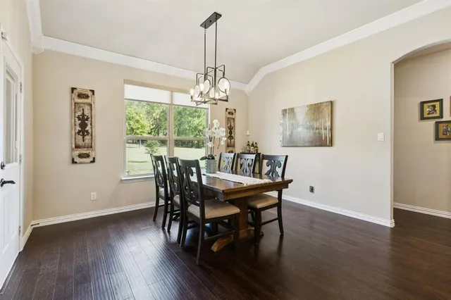 a dining room with furniture a chandelier and wooden floor