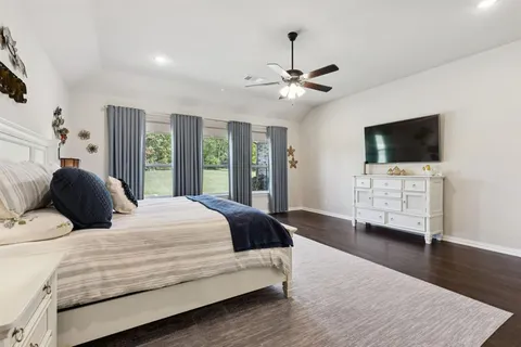 a bedroom with a bed window and a flat screen tv