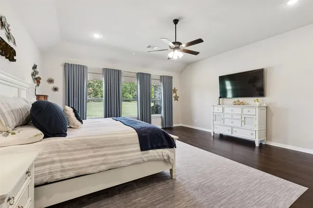 a bedroom with a bed window and a flat screen tv