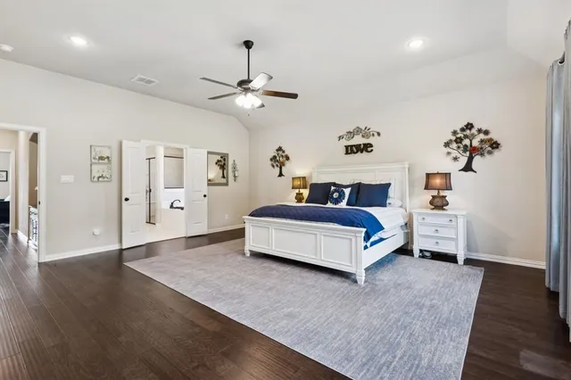 a spacious bedroom with a bed and a chandelier