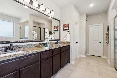 a bathroom with a granite countertop sink vanity and mirror