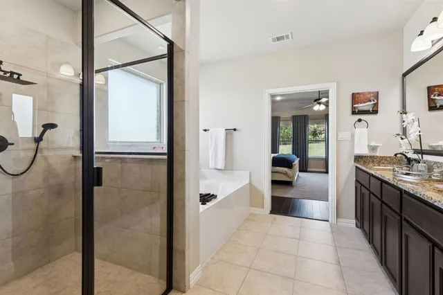 a bathroom with a glass shower door and a sink