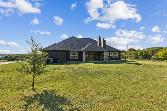 a front view of house with swimming pool and green space