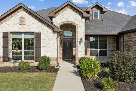a view of a house with potted plants and a large window