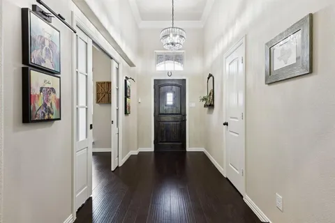 a view of a hallway with wooden floor and staircase