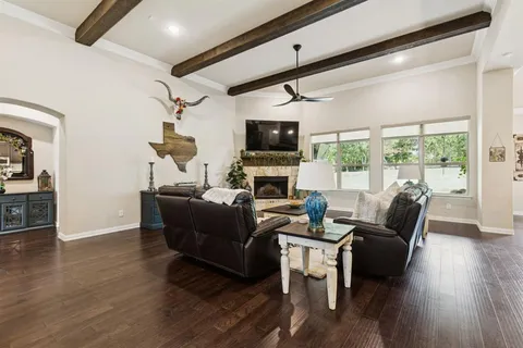 a living room with furniture a flat screen tv and a floor to ceiling window