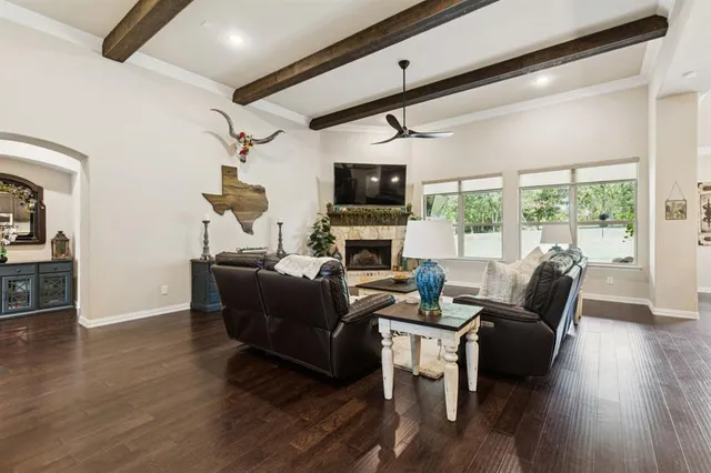 a living room with furniture a flat screen tv and a floor to ceiling window