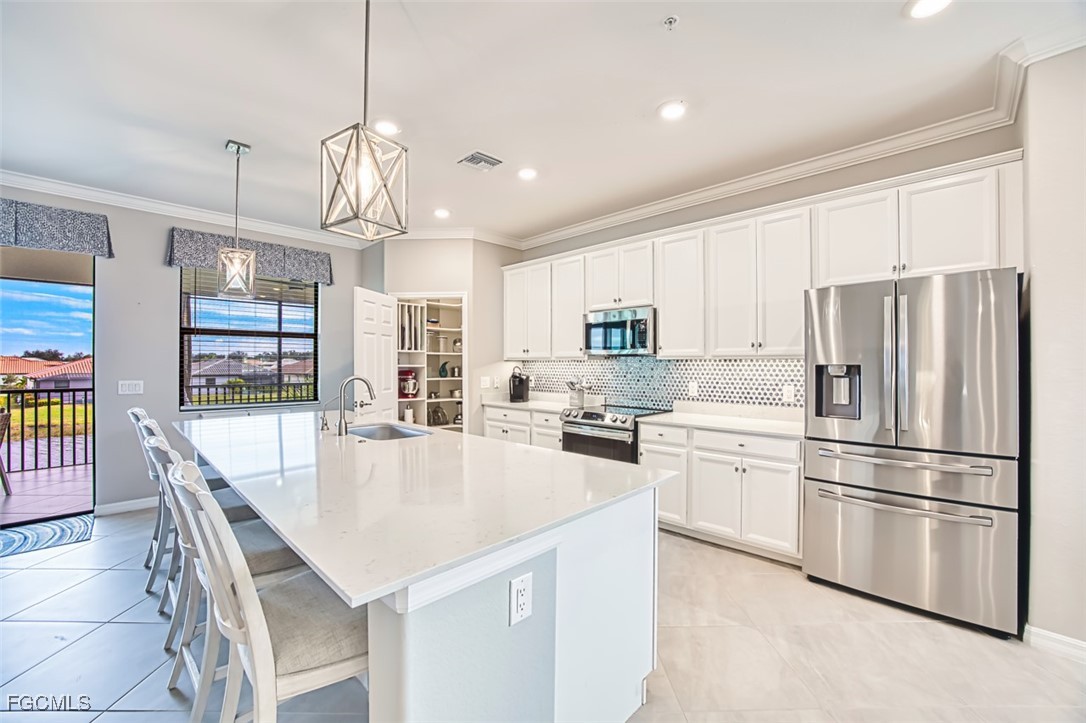 12000 Hawthorn Lake Drive, Unit 202 Fort Myers, FL 33913 - Photo 11 of 49 a kitchen with stainless steel appliances granite countertop a refrigerator a sink dishwasher a stove a dining table and chairs with wooden floor