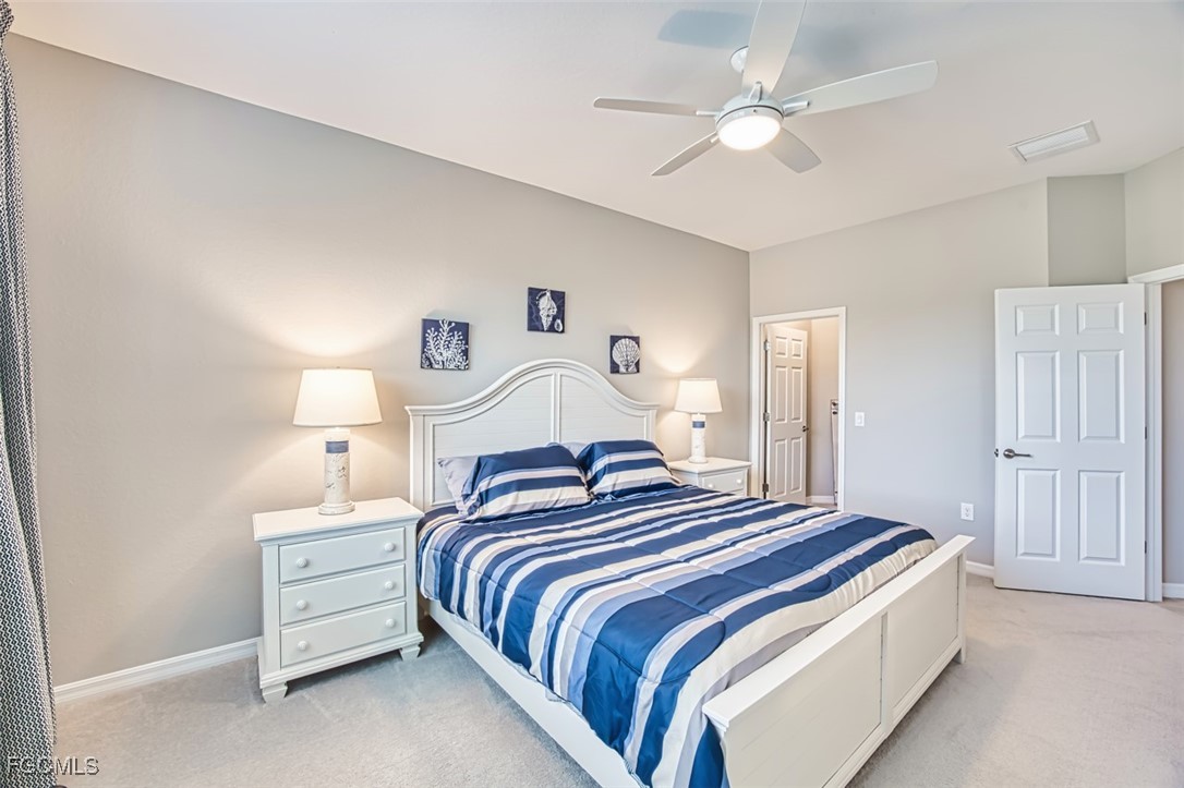 12000 Hawthorn Lake Drive, Unit 202 Fort Myers, FL 33913 - Photo 26 of 49 a bedroom with bed and a chandelier