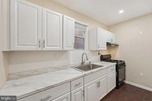 a kitchen with stainless steel appliances granite countertop white cabinets and a sink