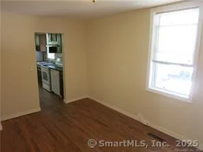 a view of a kitchen with wooden floor and a window