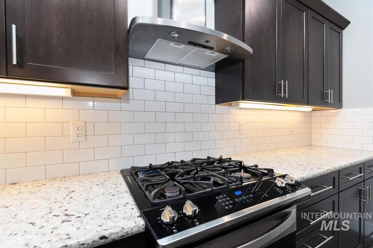 9580 West Ringle Creek Street Star, ID 83669 - Photo 15 of 43 Kitchen with gas stove, extractor fan, light stone countertops, and decorative backsplash